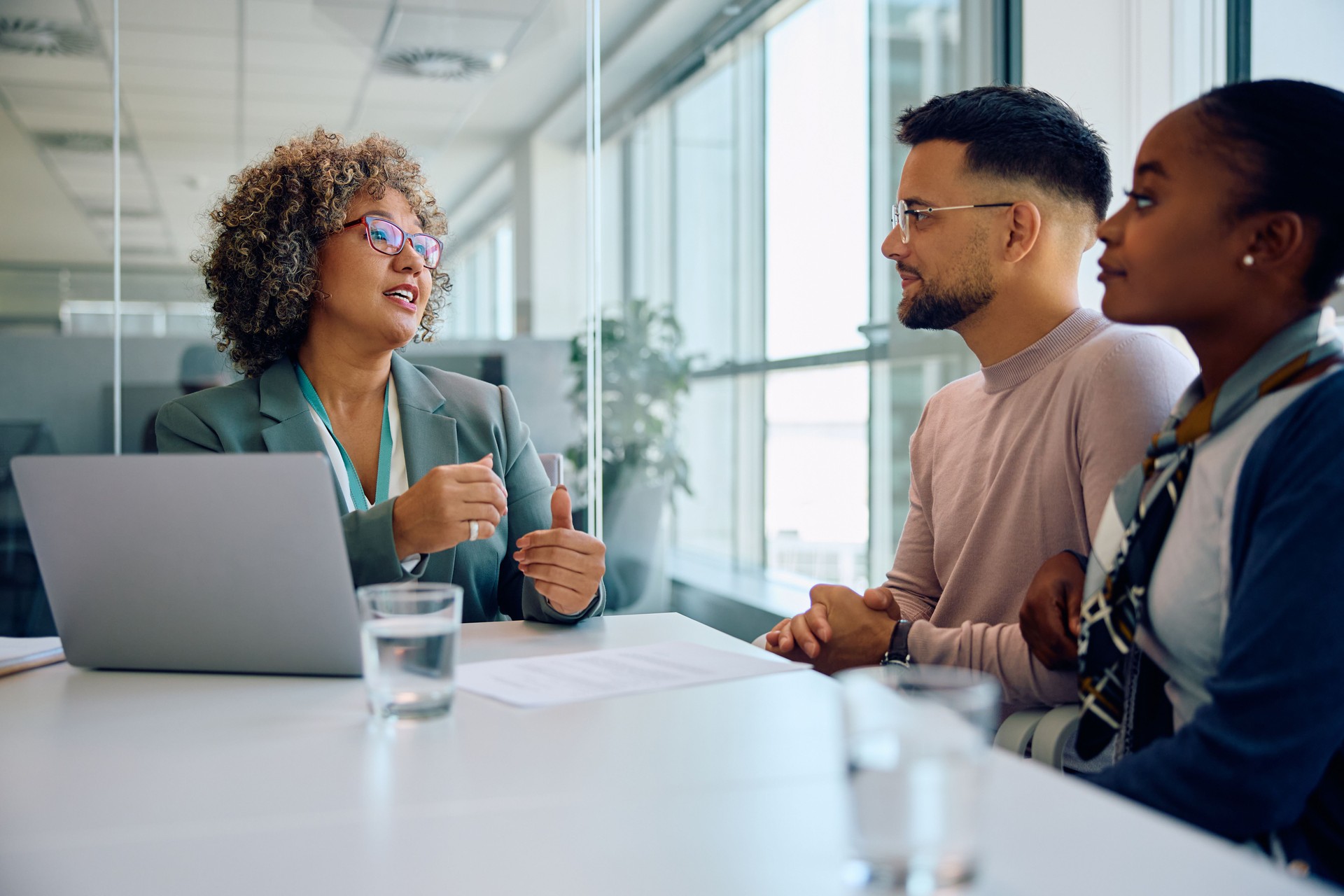 Female bank manager advising young couple during a meeting in the office.